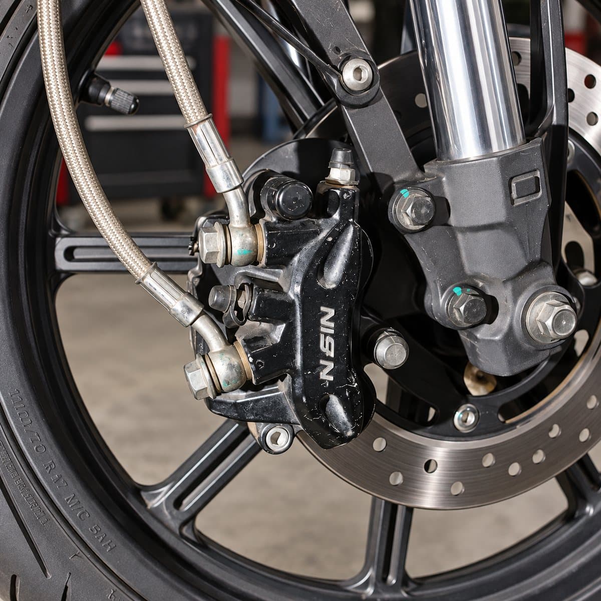 Front brake caliper and braided brake line fitted to a motorcycle fork