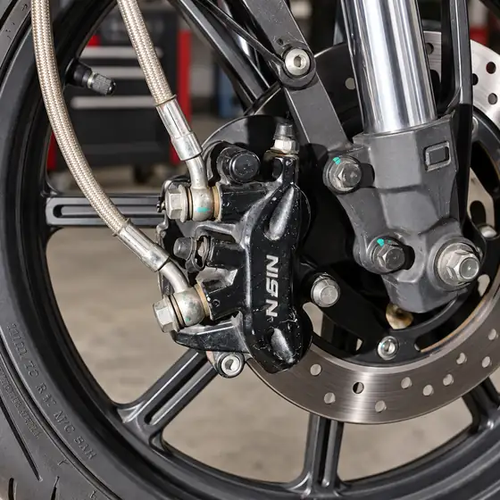 Front brake caliper and braided brake line on a motorcycle fork