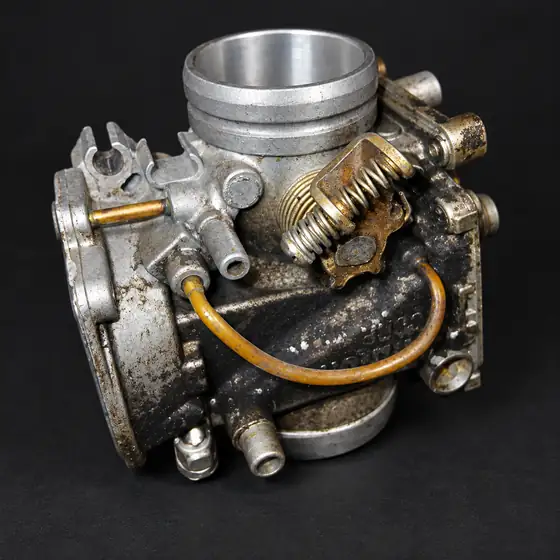 Carburettor with a dirty, corroded body before cleaning