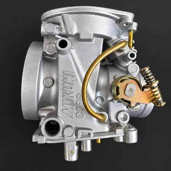 Cleaned Mikuni carburettor with brass fuel line and linkage